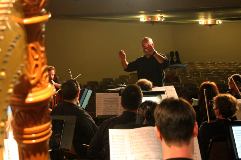 Dr. Brian Dehn conducts the orchestra.