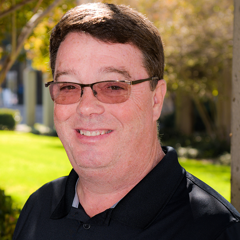 Portrait of Dr. Peter Donovan, in glasses against a natural park setting