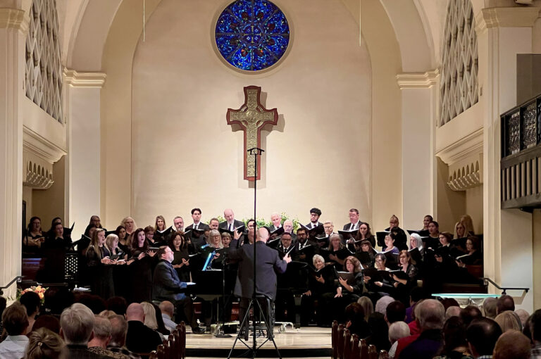 The a choir dressed in black singing in a church.