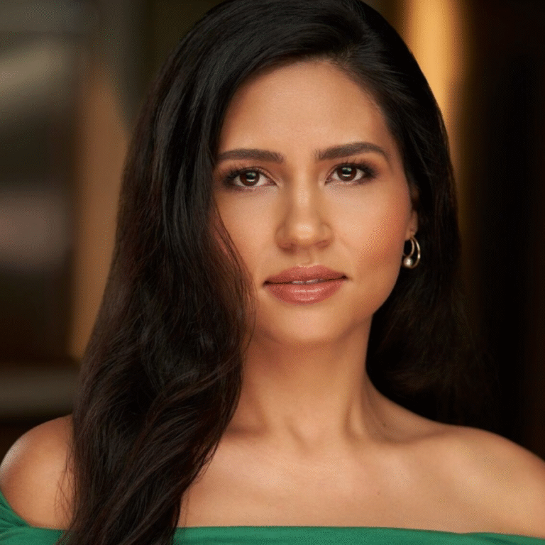 Headshot of a woman with long brown hair and a green strapless dress